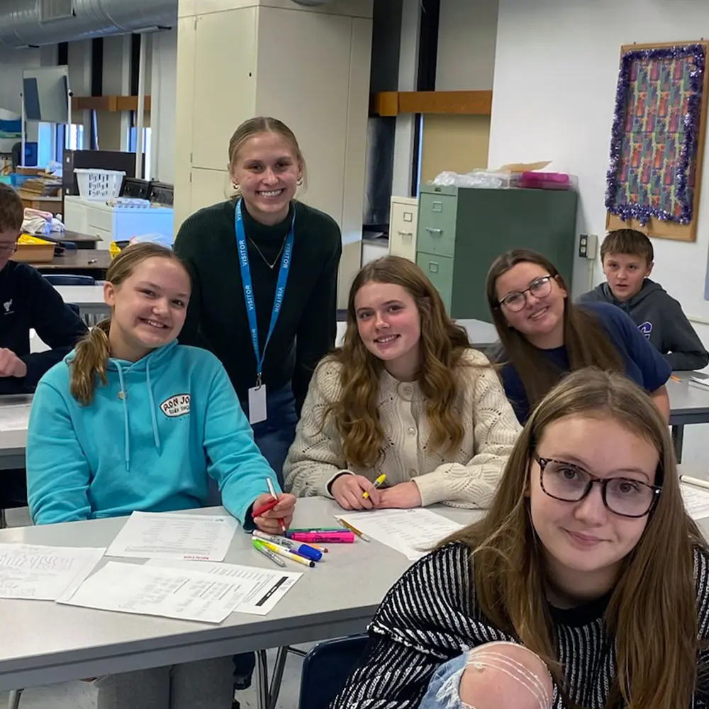 Kate S with a group of high school students smiling